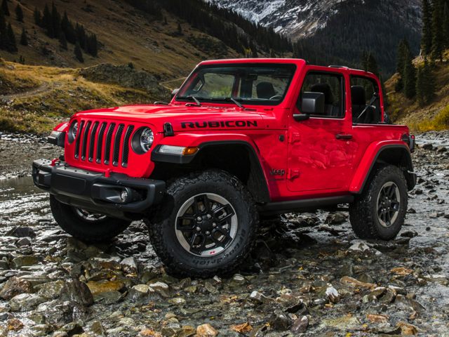 A red jeep parked in front of a louis vuitton store photo – Free